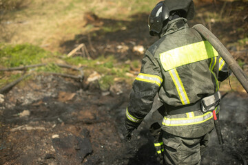 Firefighter puts out fire. Lifeguard pours water from hose.