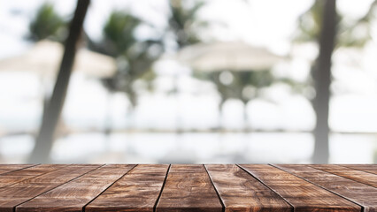 Empty wood table top and blurred summer beach bar in tropical resort banner background - can used...