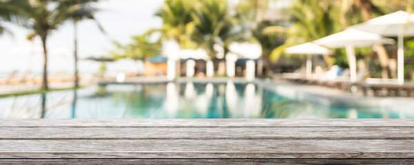 Empty wood table top and blurred summer beach bar in tropical resort banner background - can used for display or montage your products.