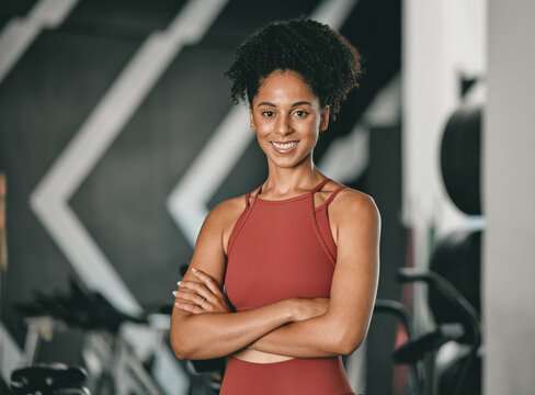 Black woman, fitness and coach with arms crossed and smile for training, exercise or workout at the gym. Portrait of a confident African American female sports instructor with vision for healthy body
