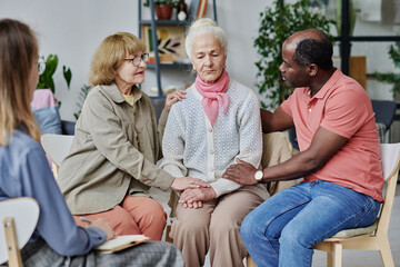 Group of people supporting senior woman while they visiting psychotherapy with psychologist