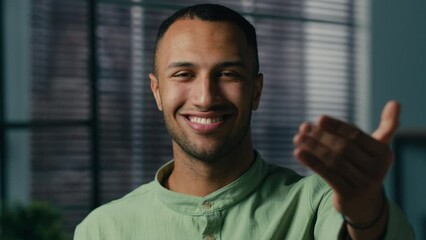 Close-up african american friendly man standing indoors looking camera making invitation gesture smiling businessman waving hand asks come here welcome sign inviting to get good job tempting invite