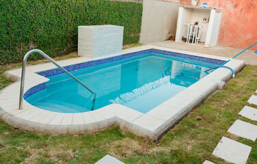 Fototapeta na wymiar A blue swimming pool with a sand suction hose. A swimming pool with suction hose under water