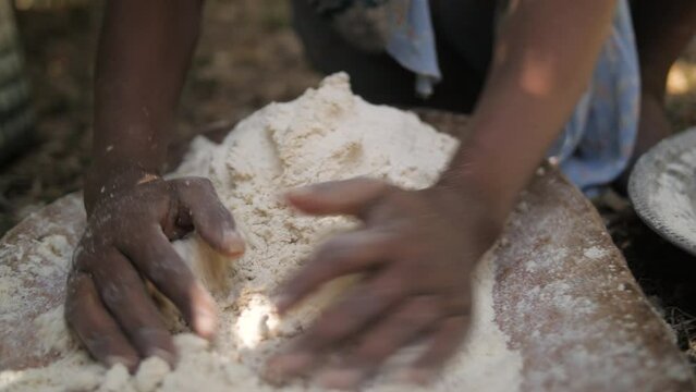 A woman kneads teff flour to make patties, in Ethiopia