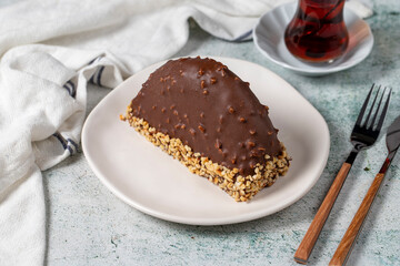Chocolate Banana Cake. Malaga cake with banana inside, chocolate and hazelnut outside on a stone background. close up
