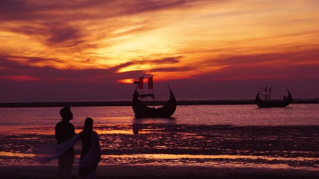 A wonderful view of the sunset in the sea. Couple standing enjoying the sunset. This is footage from Ukhia, Inani Beach, Cox's Bazar.