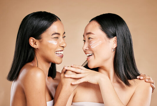 Laughing, Beauty And Excited Women With Cream For Face Isolated On Beige Studio Background. Wellness, Smile And Asian Model Friends With Sunscreen For Love Of Cosmetics And Dermatology On A Backdrop