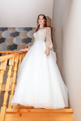 Girl in a wedding dress on a wooden staircase.