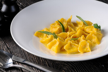 cooked ravioli decorated with herbs in a white plate

