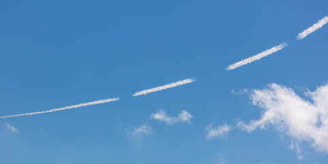 White lines from an airplane against a  sky.