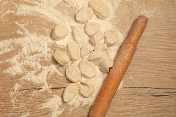 Dough with a rolling pin on the table.