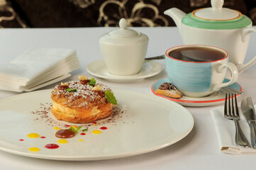 dessert cake donuts in a white plate on the table with tea
