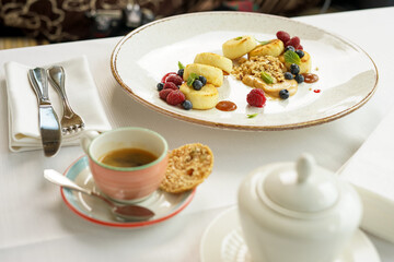 breakfast dessert sweet cheesecakes with berries in a plate on the table with tea
