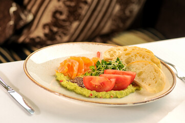 guacamole with shrimp and tomatoes in a plate with bread
