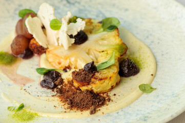 baked cauliflower with cheese and sauce in a plate macro
