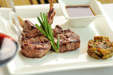 Grilled pork loin in a white plate with sauce
