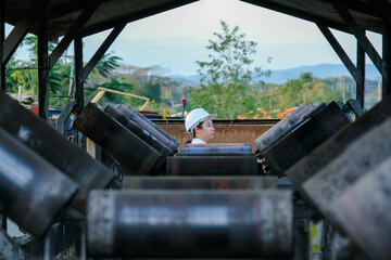 Fototapeta premium Mining engineer wearing a white helmet surveying her work place.