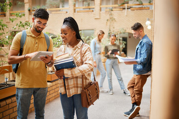 Students, college and learning, tablet and books for education, scholarship and collaboration in campus hallway. University with people studying together, learn with diversity and academic goals