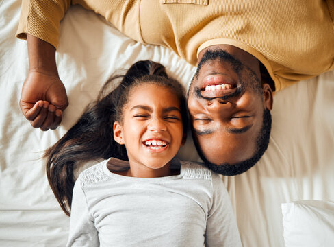Family, love and black man with girl or child lying in bed in a home smiling and bonding by having fun. Top, dad and daughter in a house with her father, face and happiness in a bedroom feeling happy