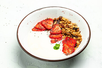 Granola with yogurt with fresh strawberry, chia seeds and honey on a white background. Delicious balanced food concept. banner, menu, recipe place for text, top view