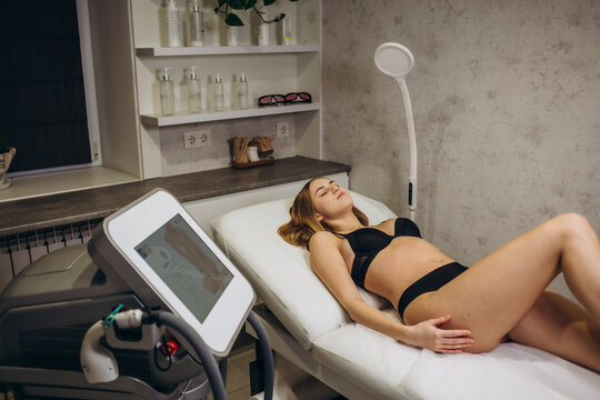 Cosmetology. Young Woman With Beautiful Body At Spa Salon Receiving Laser Hair Removal Procedure. Beautician Using Modern Apparatus For Spa Procedures. Skin And Beauty Care. High Resolution