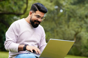 young indian man using laptop and giving expression like talking on video call.