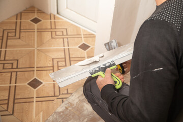 Worker is applying putty on a wall. Renovating house