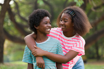 Obraz premium Happy two African American boy and girl playing and hugging together outdoor
