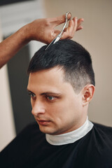 Obraz premium hairdresser does haircut for man in barber shop
