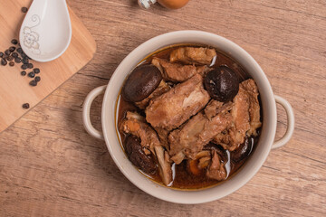 Braised pork ribs with shiitake mushrooms on wooden background
