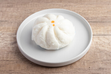Steamed pork buns in a plate on a white background