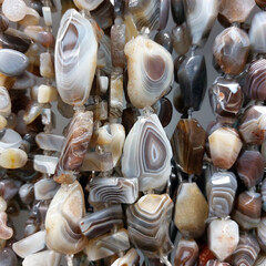 Lots of beautiful gray Botswana agate beads. Agate on a thread in a store close-up.