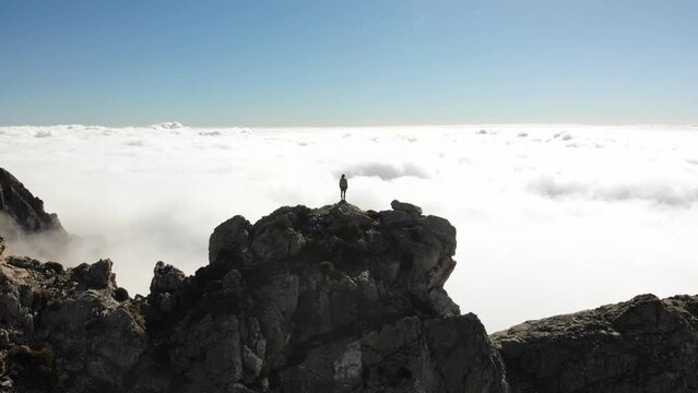 4K drone footage over woman on a rocky peak overlooking breathtaking sea of clouds at La Maroma summit, Malaga, Spain.
Mid angle, traveling movement.