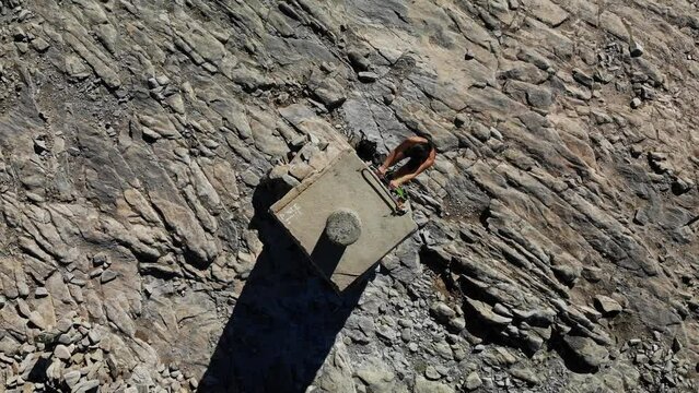 4K drone footage over woman climbing a tower on a rocky peak at La Maroma summit, Malaga, Spain.
Zenithal angle, twist movement.