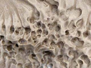 A bizarre pattern of frozen sand on the shores of the Baltic Sea in winter close-up