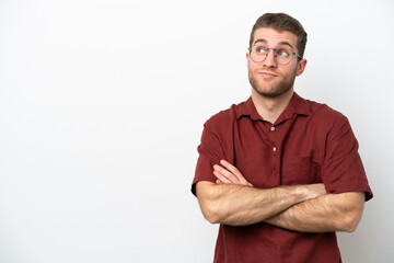 Young caucasian man isolated on white background making doubts gesture while lifting the shoulders