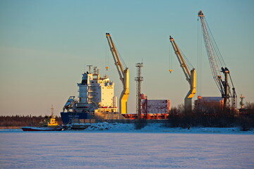 Dry cargo ship in the river port under unloading.