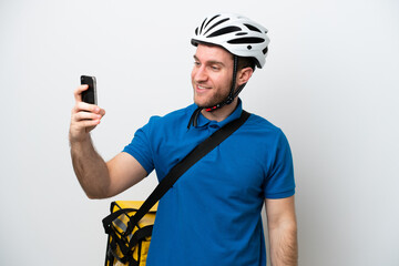 Young caucasian man with thermal backpack isolated on white background making a selfie