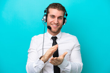 Telemarketer caucasian man working with a headset isolated on blue background applauding after presentation in a conference