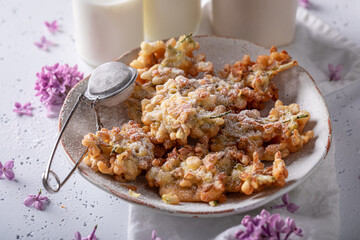 Homemade and tasty fried lilac flower with powdered sugar.