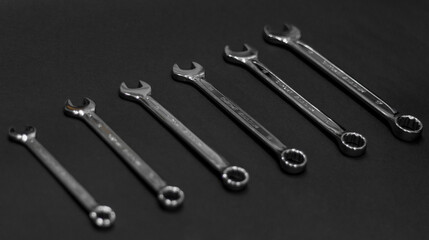 A set of wrenches made of chrome steel on a dark background lined up tools for repair and construction work and engineering. Six pieces of different sizes.