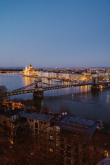Night view of Budapest showcasing illuminated buildings, bridges, and reflections on the Danube River at dusk