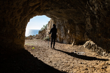 Woman trekking in a cave with access to the Mediterranean Sea in Begur Catalonia caminos de Ronda