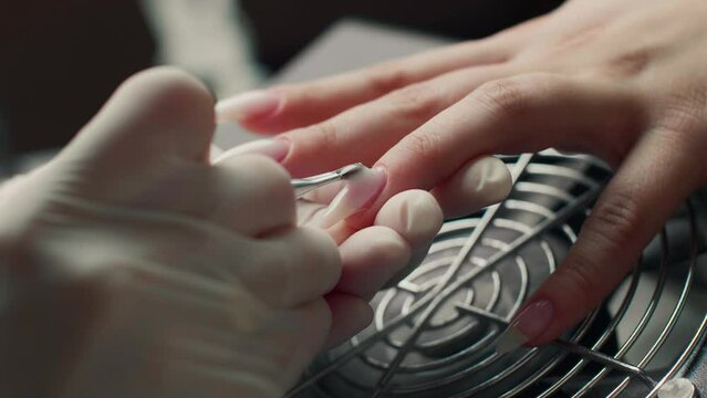 Nail extension service. Manicurist makes a manicure Gel Nail extension with professional tools for manicure.
