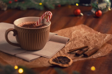 A mug of hot cocoa on a wooden table. Cozy Christmas composition. Decorations in a retro style. The feeling of a holiday. The concept of coziness, good mood and winter holidays.