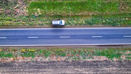 Top down drone shot of a car on the side of the road