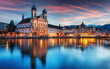 Fototapeta premium Colorful evening view of the Old Town medieval architecture in Lucerne, Switzerland. Dramatic scene with Reuss river, Jesuit church. Wonderful vivid cityscape during sunset. popular travel destination