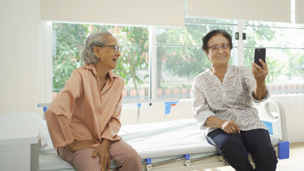 Obraz premium Portrait of happy group of old elderly Asian patient or pensioner people smiling, relaxing, having fun together in nursing home. Senior lifestyle activity recreation. Retirement community. Health care
