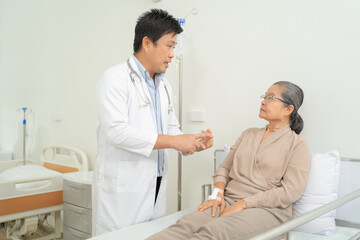 Portrait of Asian doctor check up body of sick old senior elderly patient on bed in hospital in medical and healthcare treatment at nursing home. People lifestyle