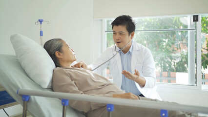 Obraz premium Portrait of Asian doctor check up body of sick old senior elderly patient on bed in hospital in medical and healthcare treatment at nursing home. People lifestyle